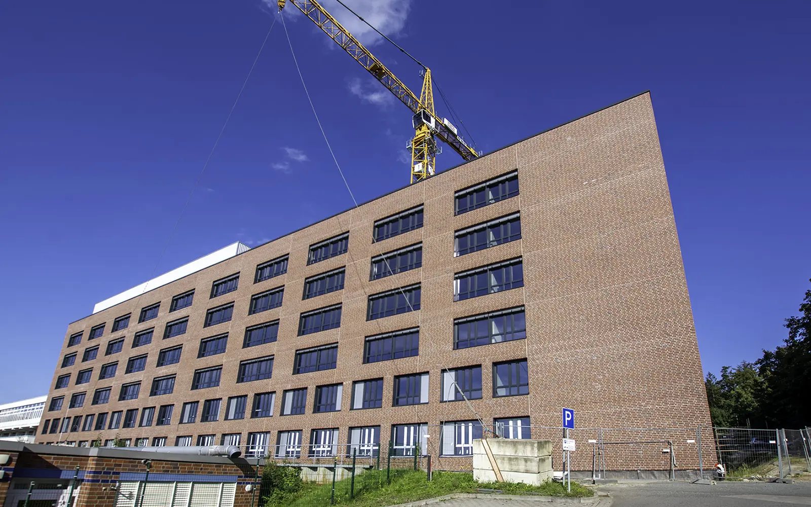 Neues Krankenhausgebäunde mit einem großen Kran im Hintergrund