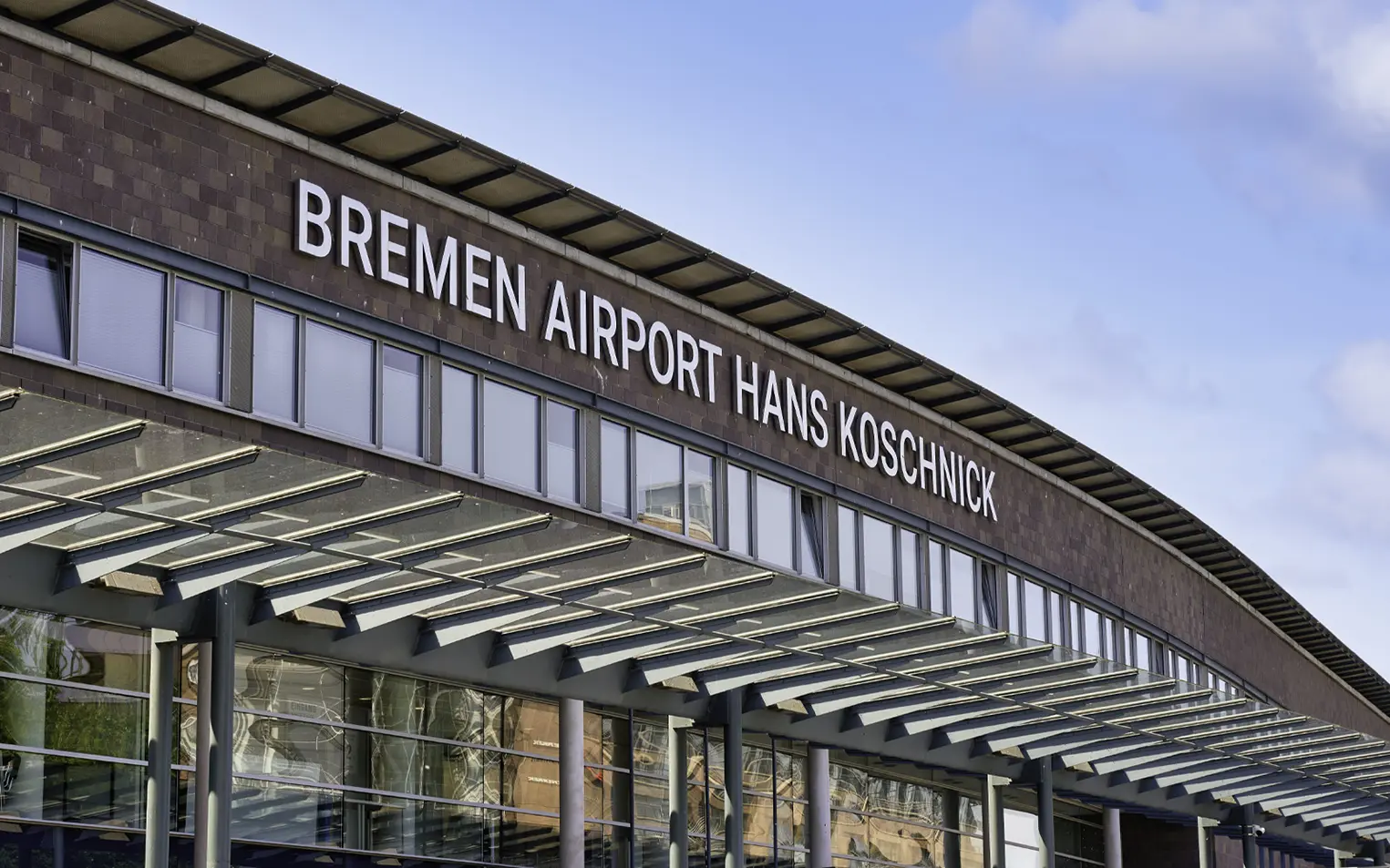 Frontansicht des Flughafengebäudes in Bremen mit dem Schriftzug Flughafen Bremen Hans Koschnick